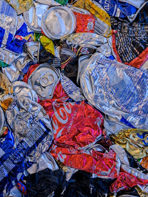 Close-up view of several black plastic rubbish bags filled with waste, stacked against a plain, light-colored wall in an outdoor or garage setting. The bags are tightly tied at the top, with the mater